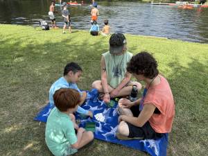 campers and counselors playing cards by lake nixon